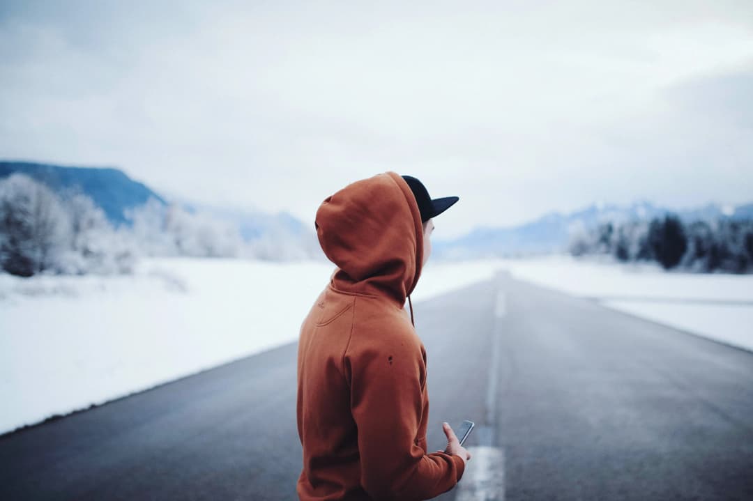 A man with an orange hoodie in a snowy place